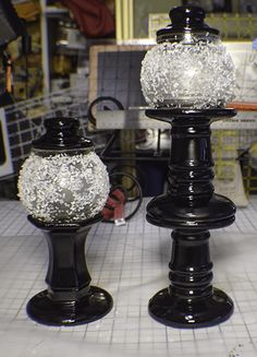 two black and white vases sitting on top of a counter