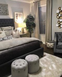 a bedroom decorated in black and white with two stools next to the bed,