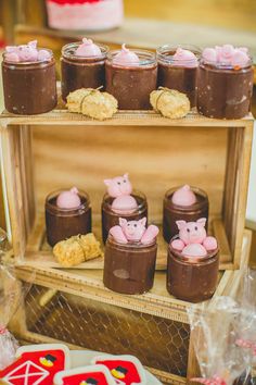 desserts are displayed in glass jars on a wooden stand at a wedding or baby shower