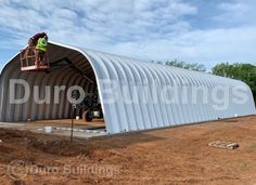 a man is working on the side of a large metal structure that's being built