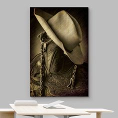 a cowboy's hat on top of a table in front of a gray wall