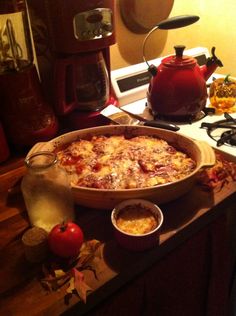 a pizza sitting on top of a wooden counter next to an oven and kettles