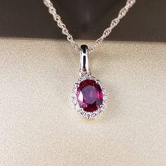 "Ruby and Diamond Pendant 14k White Gold pendant is featuring a 4.62X5.95mm Oval Genuine Ruby .69ct . This Beautiful Ruby has a Halo of .07ct Genuine Diamonds surrounding it. Classic and beautiful. **Ruby is the official July Birthstone** **Diamond is the official April Birthstone** **This listing is for the pendant only. Chain not included, for display purposes only. 14k Yellow Gold chains available for purchase upon request. **Please feel free to contact me anytime, if you have any questions o Oval Birthstone Jewelry For Valentine's Day, Oval Ruby Necklace With Brilliant Cut, Oval Fine Jewelry For Valentine's Day, Oval Gemstone Jewelry For Valentine's Day, Oval Diamond Necklace For Valentine's Day, Valentine's Day Oval Gemstone Jewelry, Oval Cubic Zirconia Jewelry For Valentine's Day, Elegant Oval Red Gemstones, Oval Lab-created Ruby Jewelry In White Gold