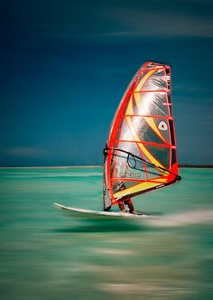 a person on a surfboard in the water with a sail attached to their body