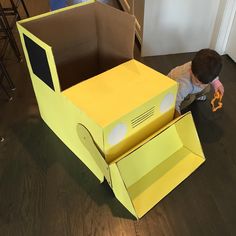 a young boy playing with an open cardboard box