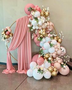 a balloon arch with balloons and flowers on it