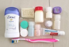 the contents of a toothbrush and other personal care items laid out on a tile floor