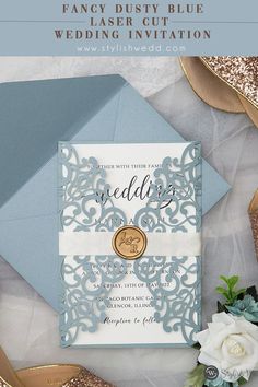 the wedding stationery is on display with gold and silver accessories, such as flowers