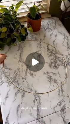 a marble table top with plants on it and a video playing about how to use the circle