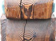 an old wooden bench with blue cushions on it's back end and wood graining