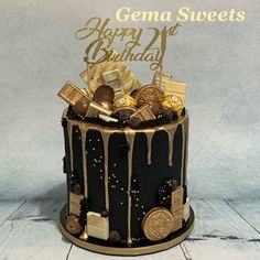 a black and gold birthday cake with chocolate decorations