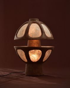 a lamp that is sitting on top of a table next to a brown wall and floor