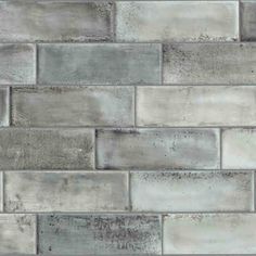 a gray brick wall with white and grey tiles