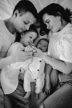 a man and two women are holding a baby