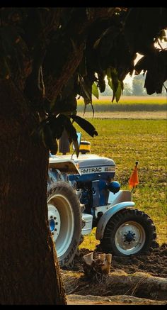 a tractor is parked next to a tree