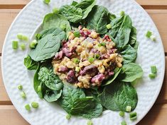 a white plate topped with spinach and other vegetables