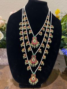 This exquisite long layered mala features intricate Jadau craftsmanship with a grand design. The necklace is elegantly layered and complemented by delicate rice beads, creating a luxurious and regal appearance. Ideal for adding a touch of sophistication to any outfit, this mala showcases traditional artistry and timeless beauty. Traditional Multi-strand Beaded Necklace For Wedding, Traditional Long Beaded Necklaces For Wedding, Traditional Temple Necklace With Polished Beads For Wedding, Elegant Mala For Rituals And Festivals, Temple Jewelry Mala With Polished Beads For Weddings, Traditional Long Necklace With 108 Beads, Traditional Beaded Necklaces With Latkans For Wedding, Traditional Multi-strand Wedding Necklace, Wedding Temple Jewelry Mala With Polished Beads