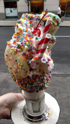 an ice cream sundae with sprinkles, candy cane and cupcake