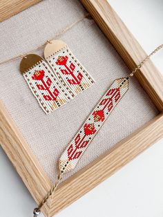 a wooden frame holding a cross stitch ornament