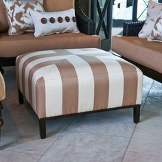 two brown and white striped couches sitting next to each other on top of a tile floor