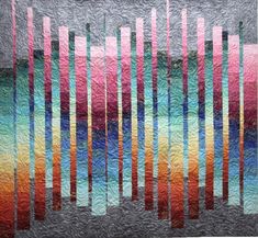 a quilted wall hanging on the side of a building with colorful bars in it