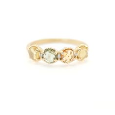 a yellow gold ring with three different colored stones