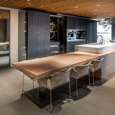 a large wooden table sitting in the middle of a kitchen next to a counter top