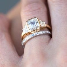 a close up of a person's hand with a ring on it and an engagement band