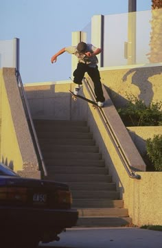 a man riding a skateboard down the side of a set of stairs