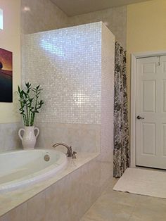 a bathroom with a tub, sink and painting on the wall