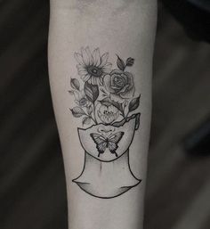 a black and white tattoo with flowers in a vase