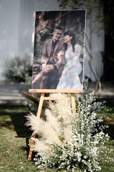 an easel with a photo on it sitting in the grass