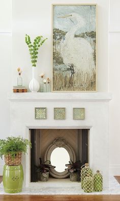 there is a white fireplace in the living room with green vases and plants on it