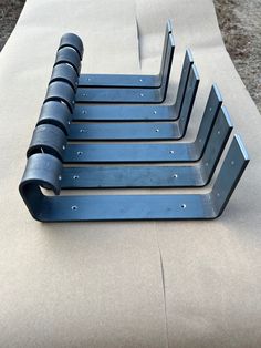 four metal brackets are sitting on the ground