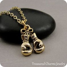 This Boxing Gloves Charm necklace comes on a gold-plated chain that is available in different lengths. Please choose your desired length from the drop-down menu when placing the item in your shopping cart. { CHARM DETAILS }★ Material: Pewter ★ Finish Color: Gold★ Measurements: 1/2" x 3/4"★ Dimensions: Two-sided★ Made in the USA{ SIMILAR ITEMS } More sports themed items available from my shop: https://www.etsy.com/shop/treasuredcharms/search?search_query=sports{ GIFT OPTIONS}Gift boxes are availa Brass Charm Necklace With Box Chain For Gift, Brass Charm Necklace With Box Chain As Gift, Brass Charm Necklace With Chain As A Gift, Gold Charm Necklaces With Box Chain For Gifts, Gold Charm Necklace With Box Chain For Gifts, Gold Charm Necklace With Box Chain As Gift, Peace Bird, Boxing Gloves, Sports Gifts