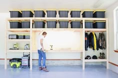 a man standing next to a shelf filled with lots of items