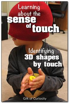 a young boy sitting on the floor wearing a red hat and holding a yellow object