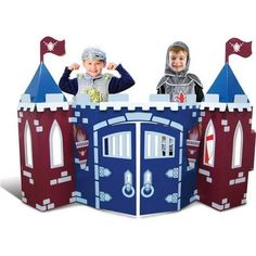 two children standing in front of a castle shaped play house with flags on it's roof