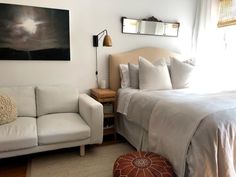 a white bed sitting next to a couch in a bedroom