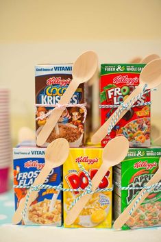 wooden spoons and cereal boxes are stacked on top of each other in front of cups