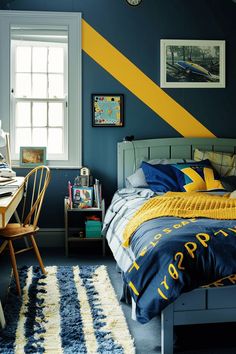 a bedroom with blue walls and yellow accents