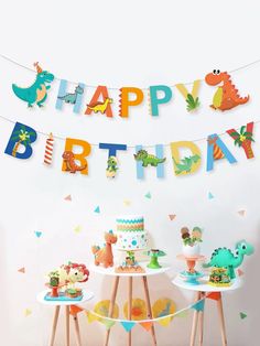 a birthday party with dinosaur decorations, cake and cupcakes on small wooden tables