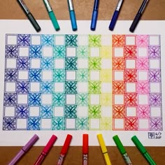 some markers are laying on top of a piece of paper that is drawn with different colors