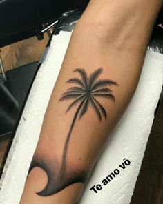 a small palm tree tattoo on the arm