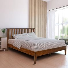 a bed sitting on top of a hard wood floor next to a wooden dresser and window