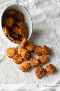 a white bowl filled with fried food next to a pile of doughnut nuggets