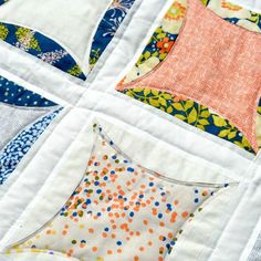 a close up of a quilt with different colors and shapes