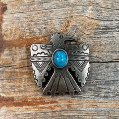 Antique silver western concho with an Aztec style Thunderbird shape. Decorated with an engraved Native American pattern and a turquoise center. This measures at 1.5". Perfect for headstalls, breastcollars, dog collars, etc. Chicago screws are included Turquoise Concho Christmas Tree Ornament, Adjustable Turquoise Western Belt Buckles, Southwestern Turquoise Concho Belt Buckles, Blue Concho Western Belt Buckles, Western Style Blue Concho Belt Buckles, Native American Pattern, Wither Strap, Native American Patterns, Chicago Screws