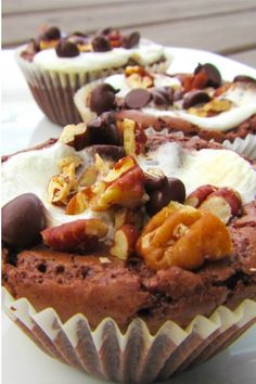 two chocolate muffins with nuts and raisins on top