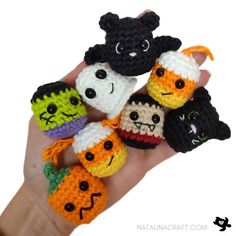 small crocheted halloween amigurt toys are displayed on a person's hand